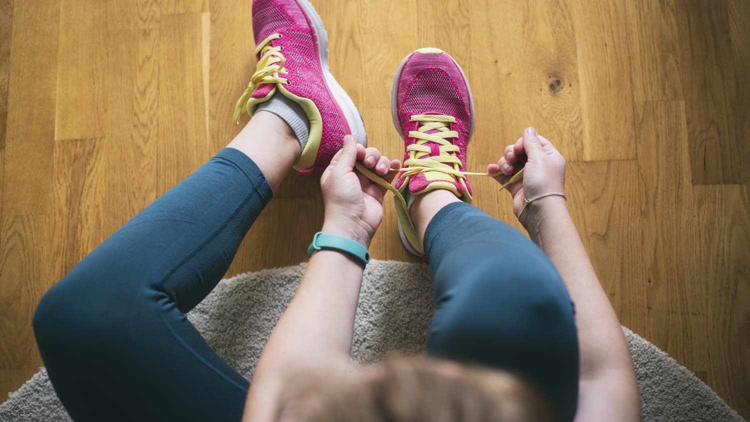 woman lacing up for a run before doing mobility exercises