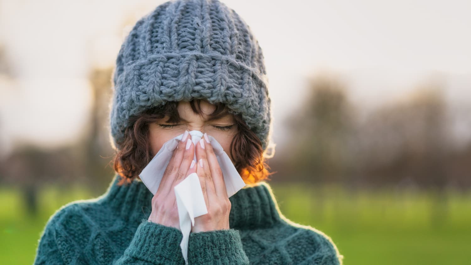 woman with 'long cold' or Long COVID sneezing