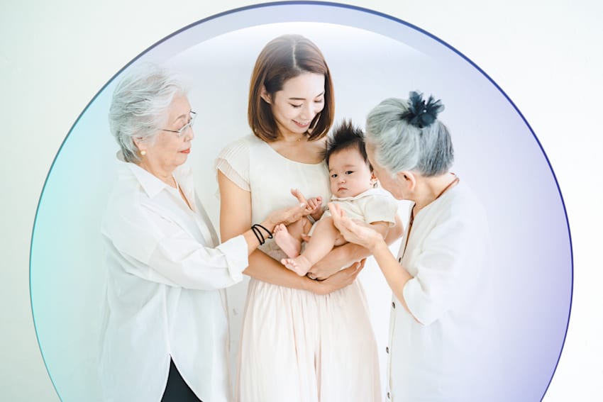 mother holding child in their arms surrounded by other family members