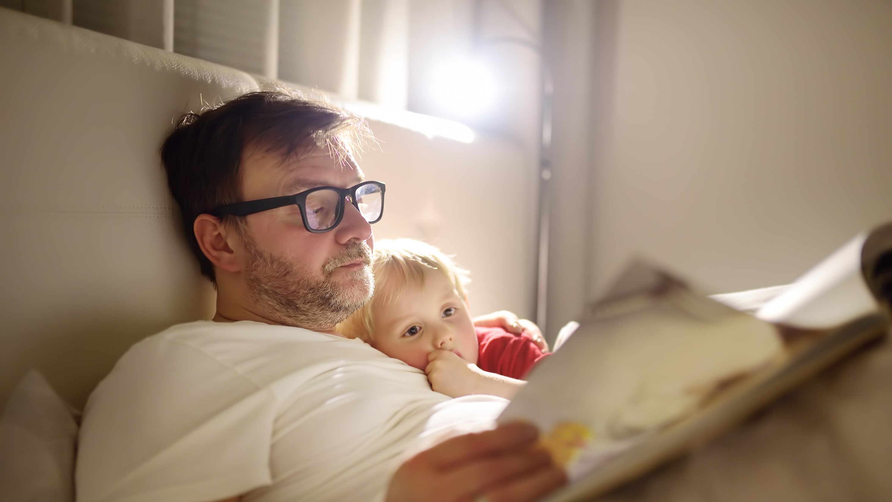 man reading with his child, unaware of his potential risk for HPV-associated oropharyngeal cancer
