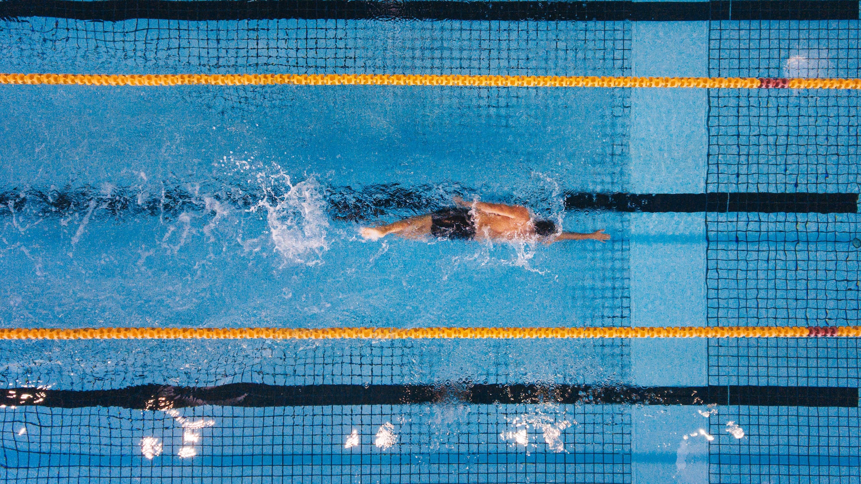person swimming laps in a pool, showing good lung health