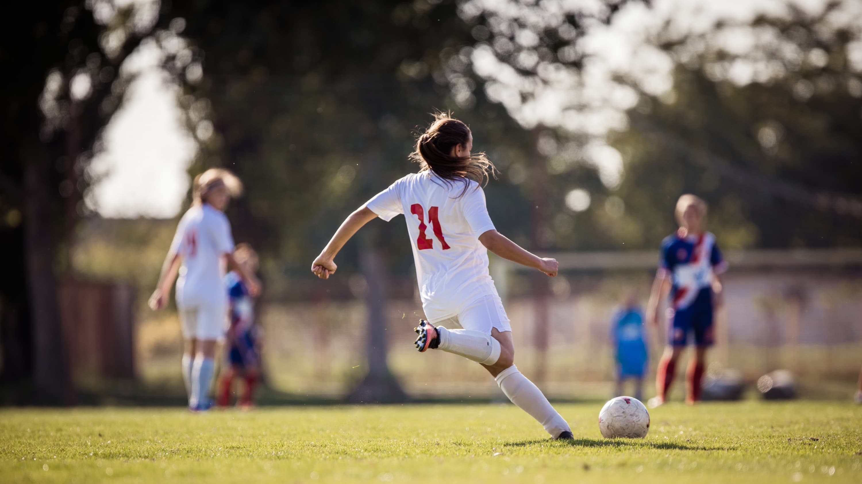 female soccer player kicking a soccer ball