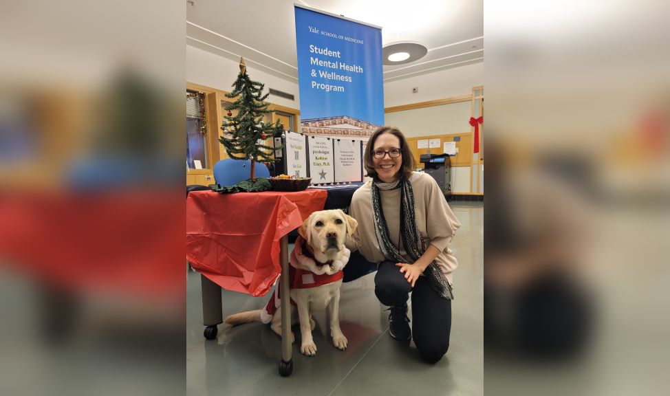 Sundari Birdsall smiles next to therapy dog Heidi